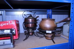 A decorative copper kettle on wrought iron spirit heater stand and a copper fondue saucepan with