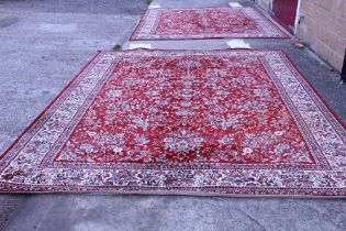 An approx. 13' x 9'10" red and floral patterned ru