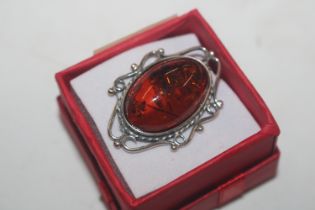 A vintage silver and amber set brooch