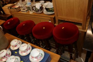 Four red upholstered bar stools