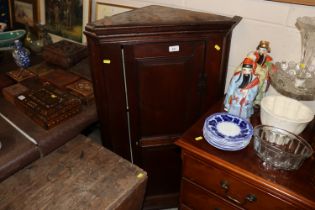 An antique oak corner cupboard