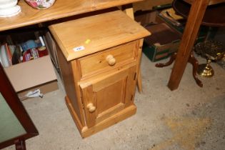 A pine bedside cupboard fitted single drawer