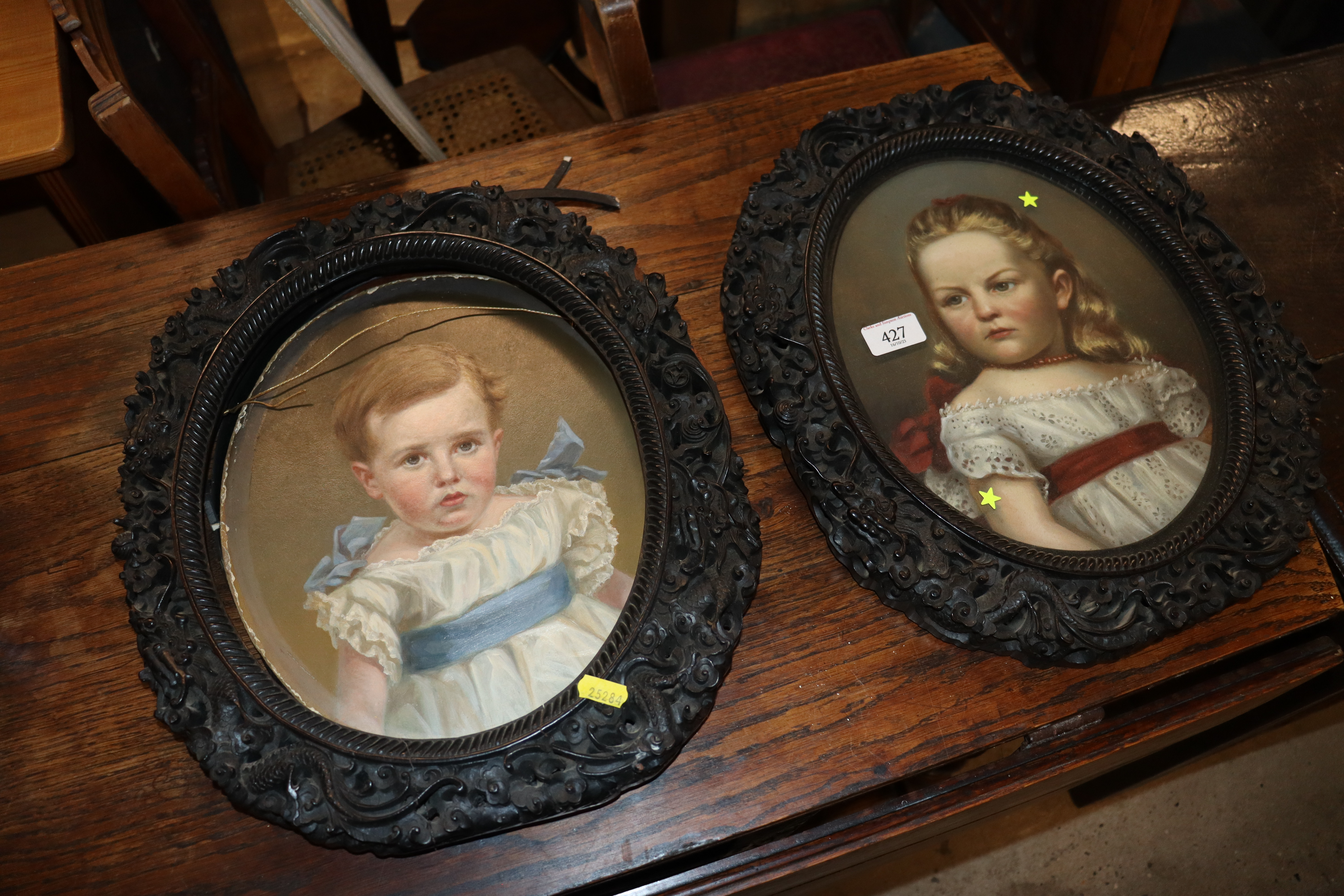 A pair of Victorian oval portraits, unsigned, contained in carved Ebonised frames