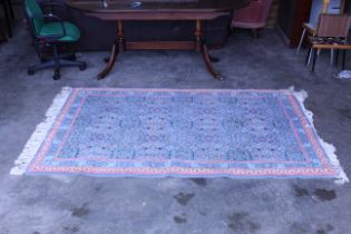 An approx. 7' x 4'9" blue patterned rug AF