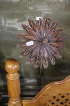 A decorative metal flower ornament on metal stake