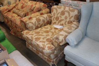 A cream floral upholstered deep seated armchair