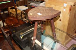 A small three legged stool with shield shaped seat