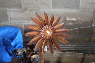 A decorative metal flower ornament on metal stake