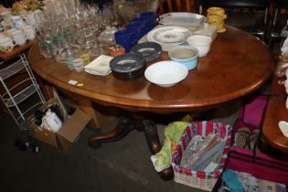 A Victorian walnut oval table raised on carved bas