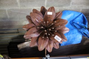 A decorative metal flower ornament on metal stake