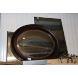 An oval framed bevel edged wall mirror together wi