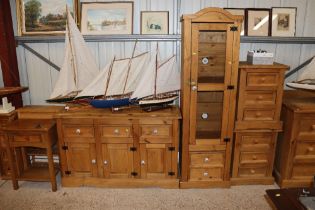 A pine display cabinet fitted two drawers below an