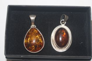 Two Sterling silver and amber pendants
