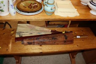 A large Oriental decorated fan and parasol