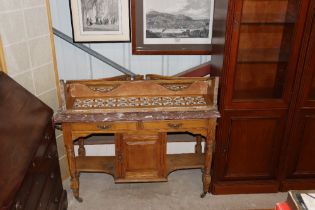 An oak and marble topped washstand with tiled back