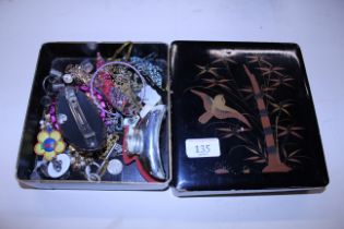 A lacquered box and contents of costume jewellery
