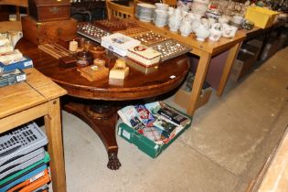 A Victorian rosewood supper table raised on paw fe