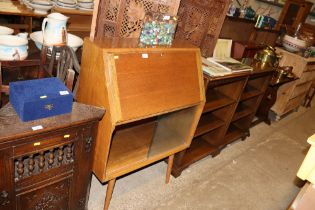 An oak bureau with bookcase below enclosed by glas