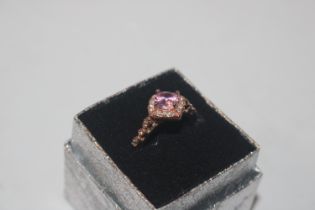 A yellow metal ring set with pink and white stones