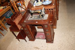 A Singer treadle sewing machine with various acces