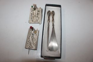 A silver handle shoe horn and button hook and a co