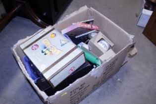 A box of miscellaneous items including a box set of Laurel and Hardy DVDs, toys and novelty items