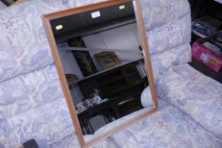 A modern teak effect framed wall mirror