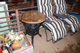 A cast iron based pub table with circular wooden top