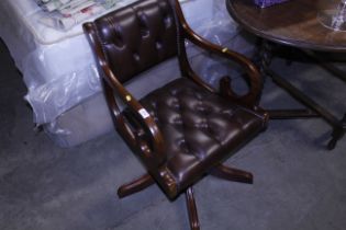 A mahogany framed and button upholstered swivel de