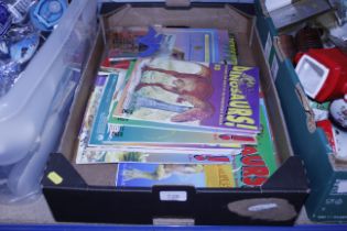 A box of children's dinosaur magazines, books and