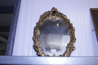 A gilt framed decorative wall mirror