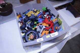 A box of Lego Technic, part built pieces of robots and motorbike