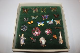 A box of enamel and other decorated brooches