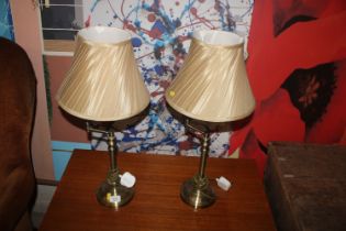 A pair of brass lamps and shades