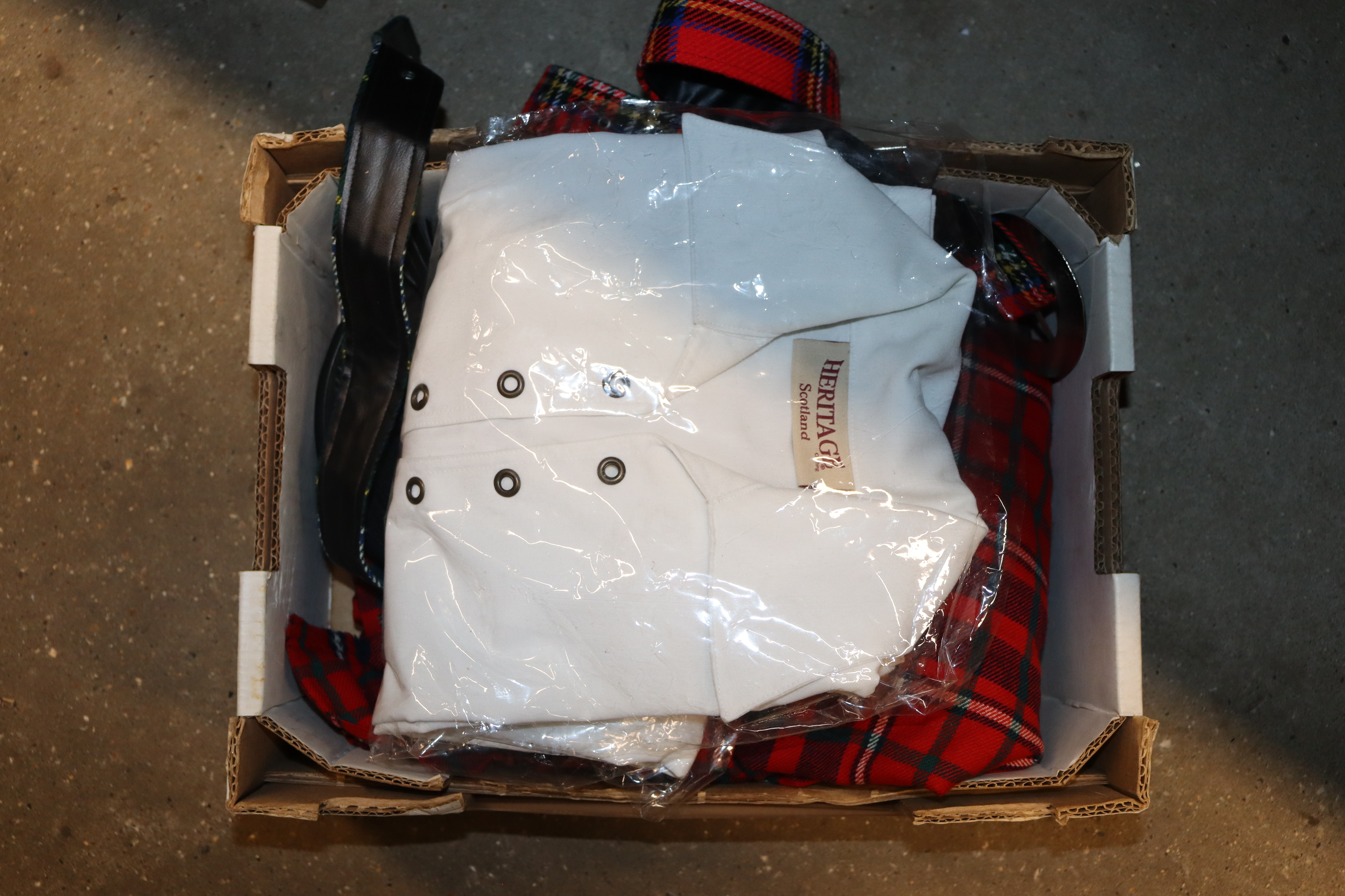 A box containing a kilt, shirt and sporran