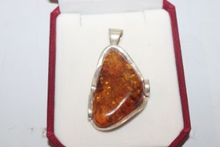 A large Sterling silver and amber pendant, approx.