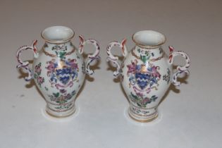 A pair of porcelain twin handled vases decorated w