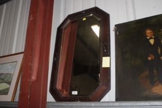 An octagonal oak framed bevel edged wall mirror