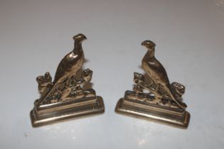 A pair of brass stands decorated with pheasants