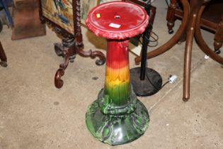 A red, green and yellow jardiniere stand