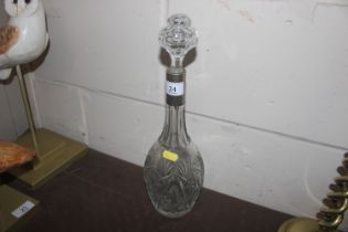 A cut glass decanter and stopper with white metal