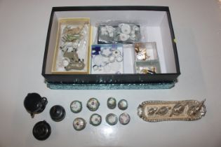A box containing miniature ornaments and part tea