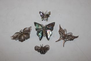 A box containing five silver butterfly brooches