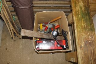 A box containing Olympia Tools heat gun and various garden hand tools