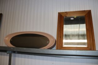 A pine framed bevel edged wall mirror and an oval plastic framed retro wall mirror