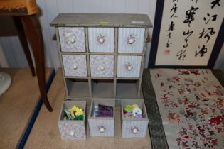 A painted wooden multi drawer cabinet and contents