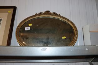 An oval gilt framed bevelled edge wall mirror