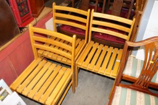 A set of three slat seated dining chairs