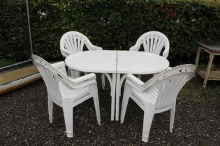 A plastic garden table with eight chairs