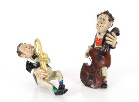 A pottery study of a seated saxophonist and a stan